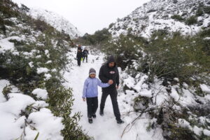 Personas caminan después de una tormenta de nieve en el sur de California (EE.UU.), este 26 de febrero de 2023. EFE/EPA/Ringo Chiu