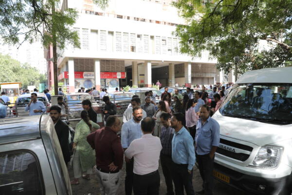 Gente fuera de sus oficinas después de sentir un terremoto en Nueva Delhi.