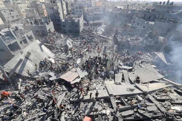 Gazatíes buscan entre los escombros en unos edificios residenciales bombardeados en Khan Yunis.