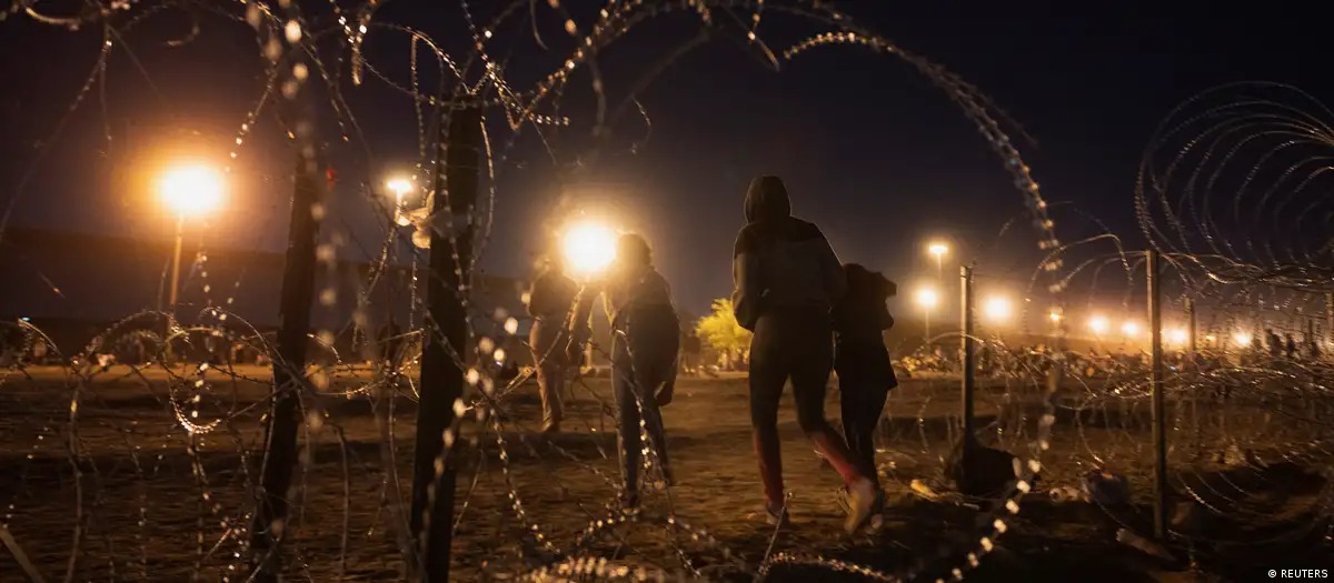 Migrantes cruzan un hueco en una valla de serpentina metálica, cerca del muro fronterizo entre México y Estados Unidos en El Paso, Texas. Foto: fuente externa.