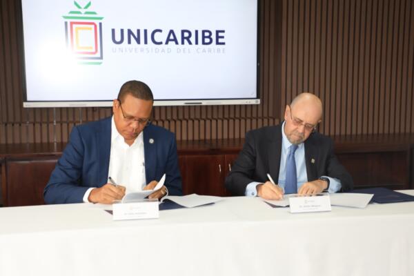 El director ejecutivo de Pro Consumidor, Eddy Alcántara Castillo, y el rector de UNICARIBE, Emilio Mínguez Torres, en el acto de la firma de convenio. (Foto: Fuente Externa)