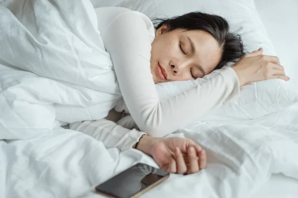 Una mujer dormida con su dispositivo celular al lado. Foto: Fuente externa. 