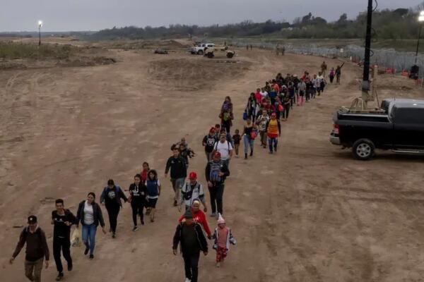 Migrantes, principalmente de Venezuela, caminan hasta un centro de procesamiento después de cruzar el Río Grande en Eagle Pass, Texas. Una nueva ley que entrará en vigencia en marzo permitirá a Texas encarcelar a los indocumentados. Foto: fuente externa.