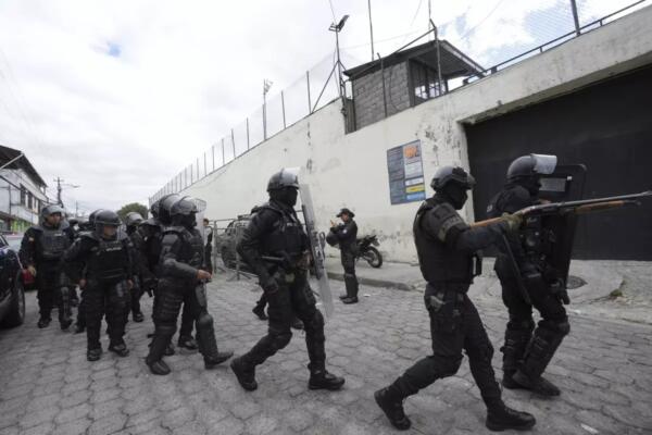 Policías y soldados se preparan para ingresar a la prisión El Inca donde se registran disturbios, en Quito, Ecuador.