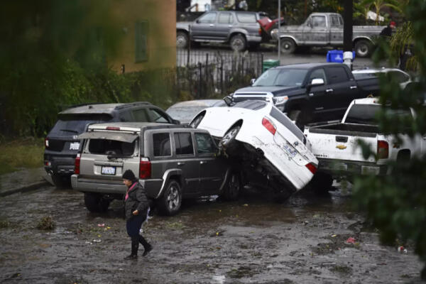 Una mujer camina junto a automóviles dañados por las inundaciones durante una tormenta el lunes 22 de enero de 2024 en San Diego. / Fuente externa.