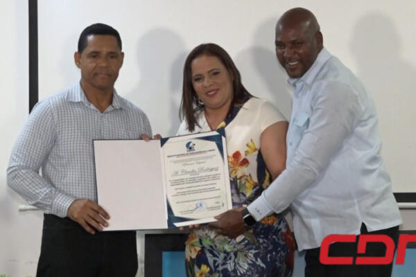 Periodista Claudia Rodríguez recibiendo reconocimiento por su destacado trabajo en los medios de comunicación. 