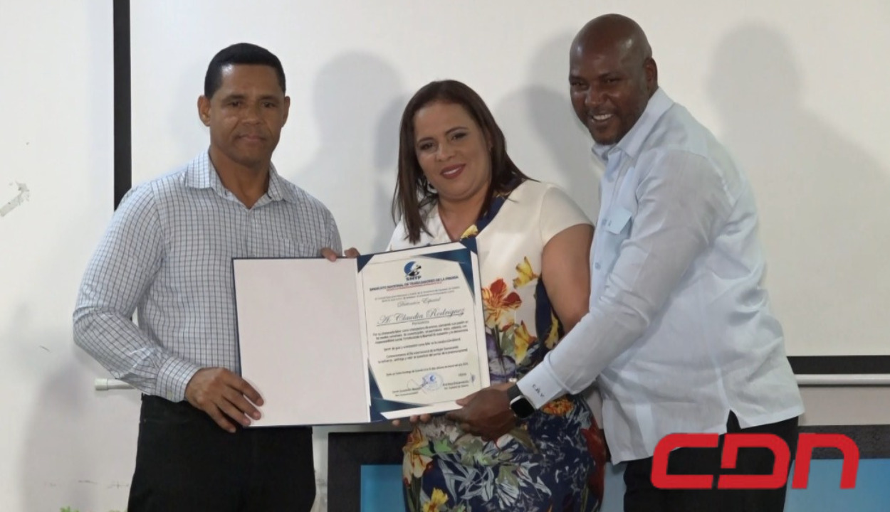 Periodista Claudia Rodríguez recibiendo reconocimiento por su destacado trabajo en los medios de comunicación.
