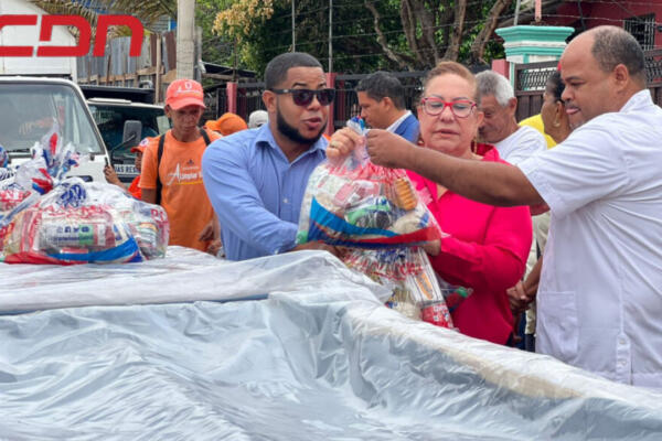 Gobernadora Rosa Santos repartiendo ayuda a familia afectada por incendio en Santiago. 