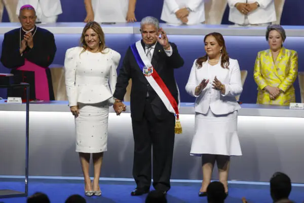 El presidente de Panamá, José Raúl Mulino (c), saluda acompañado por su esposa, Maricel Cohen de Mulino (i), luego de recibir la banda presidencial de parte de la presidenta de la Asamblea Nacional de Panamá, Dana Castañeda, durante su investidura este lunes, en la Ciudad de Panamá (Panamá). EFE/ Bienvenido Velasco