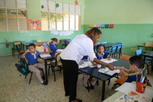 Maestra da instrucciones a sus estudiantes de como hacer manualidades en la escuela Ramón Julian Peña. Félix de la Cruz