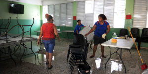 Conserjes de un centro educativo limpian un salón de clases. Félix de la Cruz