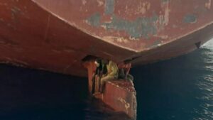 La desgarradora imagen de tres migrantes en el timón de un barco