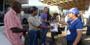 Voluntarios entregan kits de higiene a los transeúntes de la parada del kilómetro nueve de la Autopista Duarte. Johnny Rotestán
