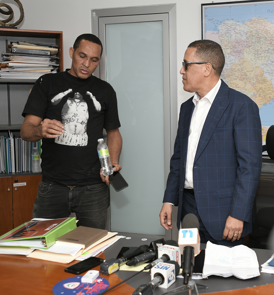 Viceministro de Obras Públicas escucha las quejas de Miguel Antonio Gómez Vargas, hobre que se subió a la torre del Estadio Quisqueya.