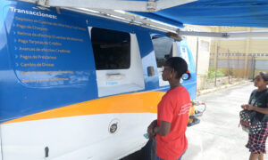 Unidades móviles del Banco Banreservas habilitadas en escuela, para el retiro de la ayuda de 1,000 pesos. Luduis Tapia