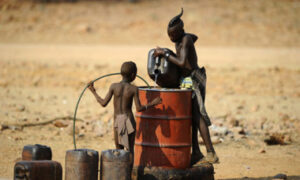 Un hombre y un niño vierten agua en un tanque, Namibia. STEPHANE DE SAKUTIN/AFP via Getty Images