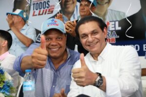 El coordinador nacional del Movimiento “Todos con Luis”, Eddy Alcántara, levanta las manos junto al candidato a senador por el PRM y aliados, Daniel Rivera, en señal de victoria, en la actividad celebrada en Santiago.